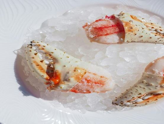 Crab claws presented on a bed of crushed ice.