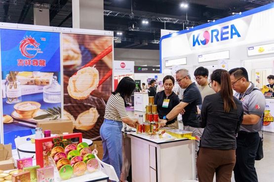 Visitors exploring food products at a trade show booth with colourful packaging displays 