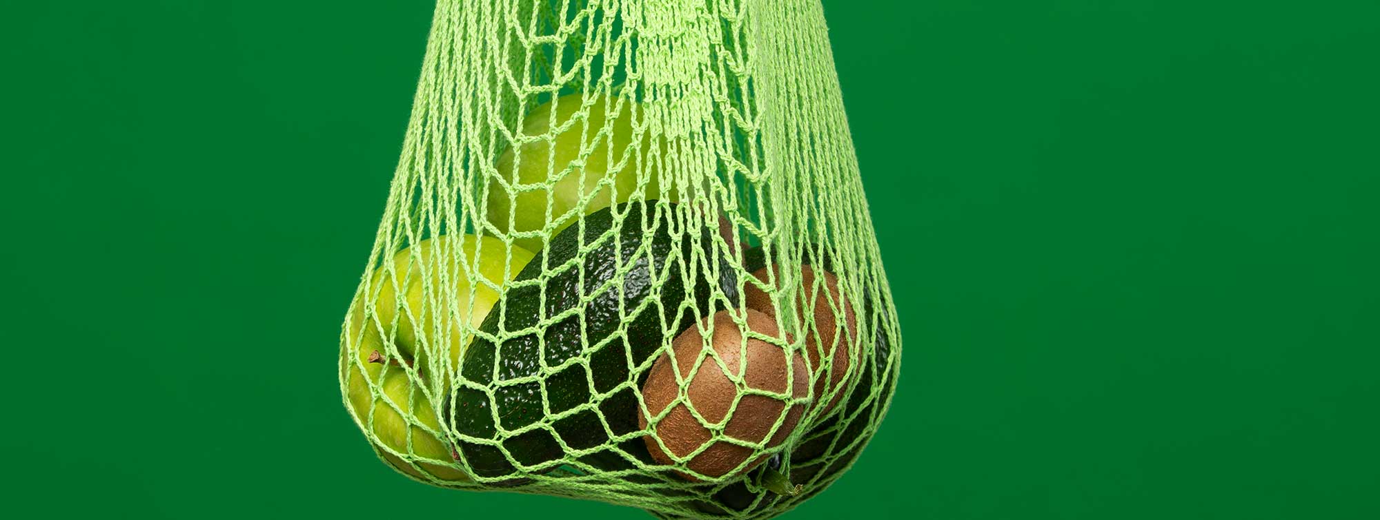 Fruit in a bag with a hand and green background