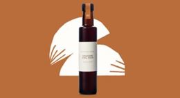 Oil bottle on a brown background with a white graphic shape behind it.