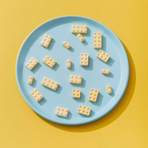Blue plate with yellow LEGO-style blocks on a yellow background.