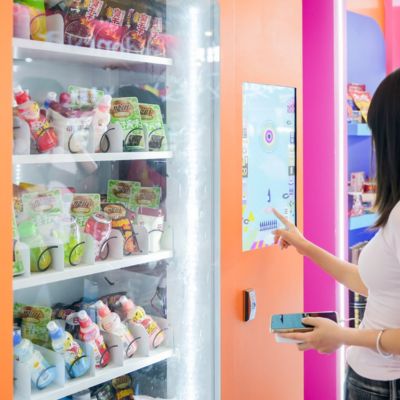 Visitor exploring innovative snack products through an interactive smart vending machine at SIAL Shanghai.