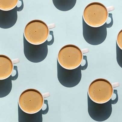 Coffee cups arranged in a repetitive pattern on a light blue background.
