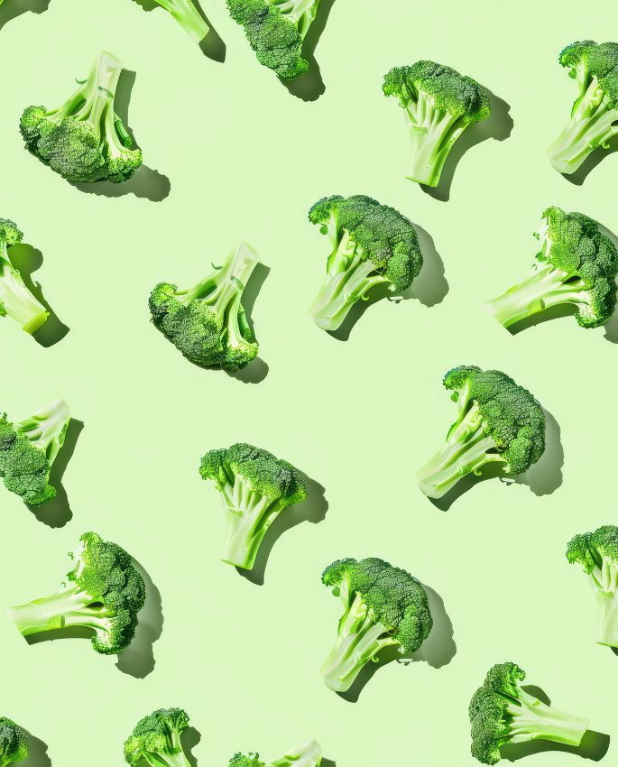 Pattern of broccoli pieces on light green background, fresh and minimal repetitive composition